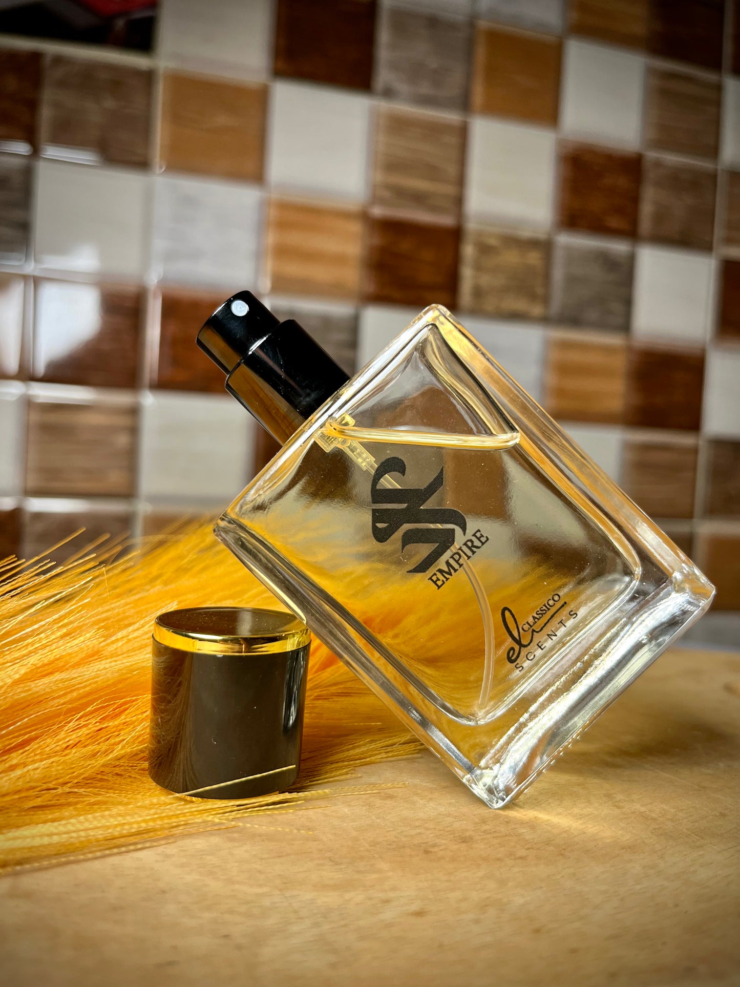 Perfume bottle with gold cap on a wooden surface with tiled wall background