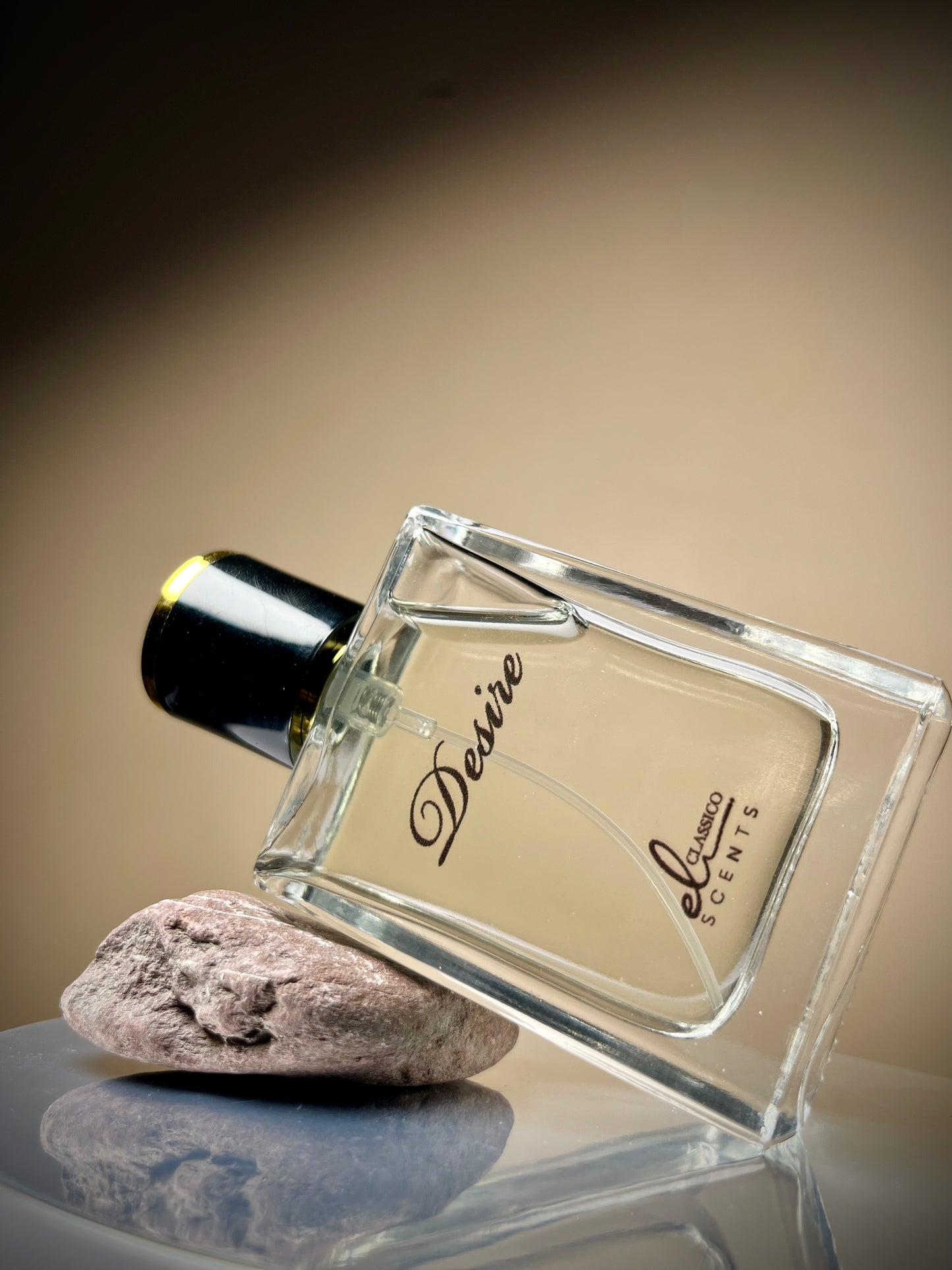 Perfume bottle labeled 'Desire' by Elektra Scents on a reflective surface with a neutral background