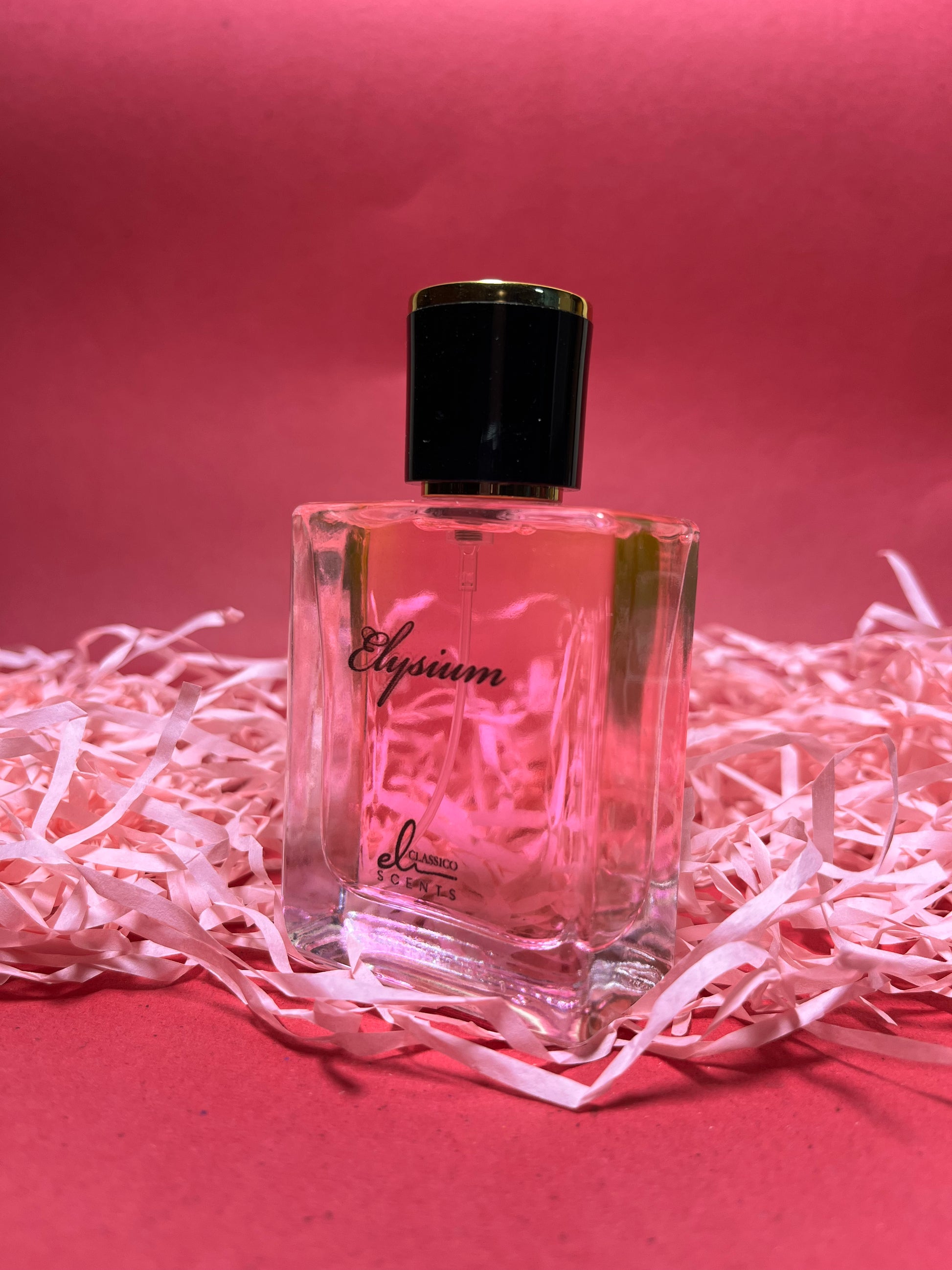 Perfume bottle labeled 'Elysium' on a pink background