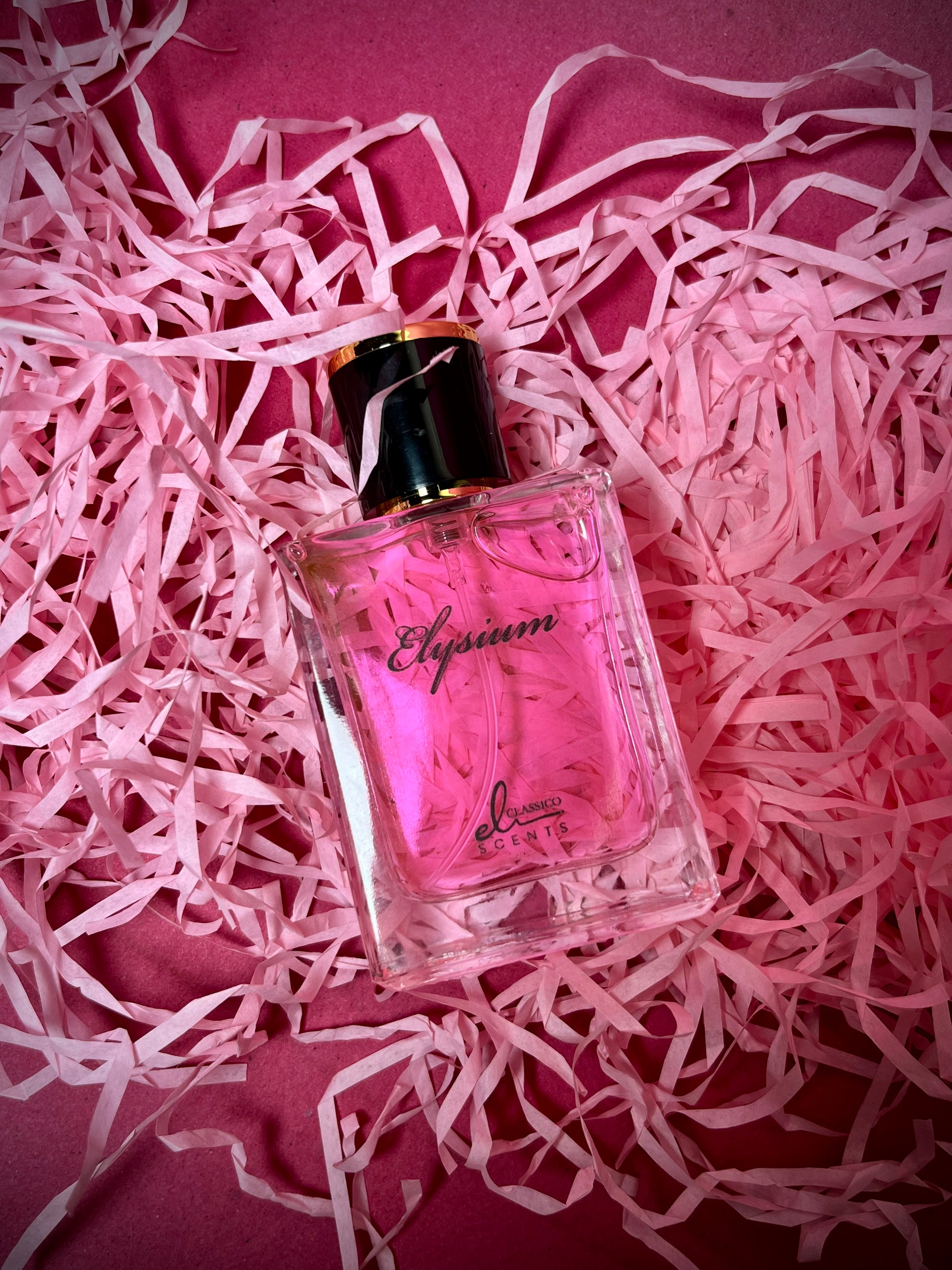 Perfume bottle labeled 'Elysiun' on pink shredded paper