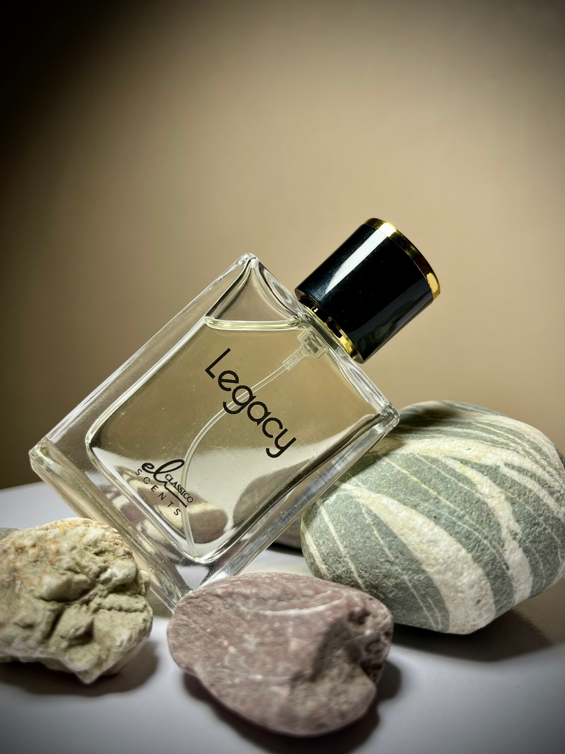Perfume bottle labeled 'Legacy' on a neutral background with rocks.
