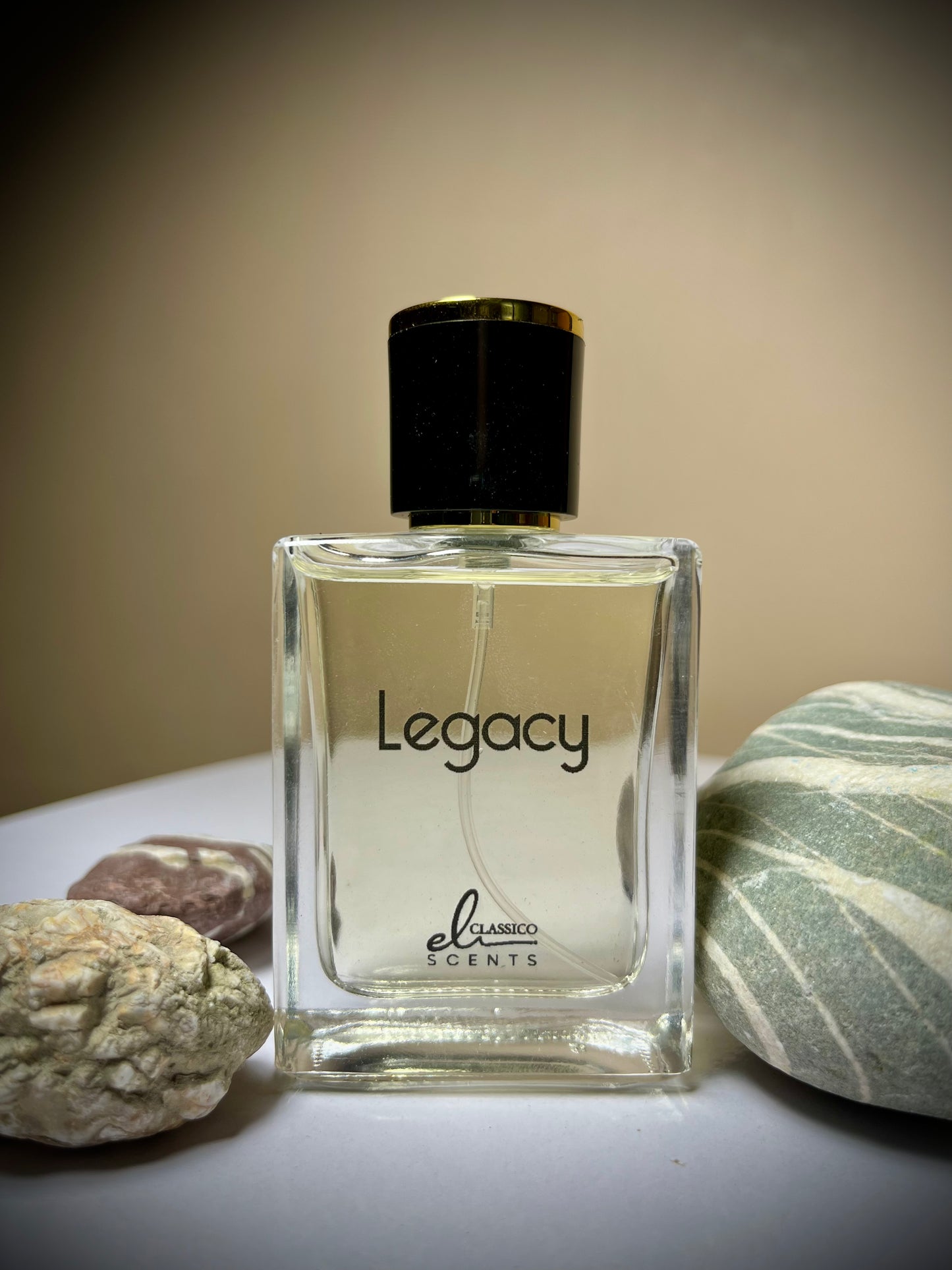 Perfume bottle labeled 'Legacy' by 'el clasicos scents' with rocks in the background