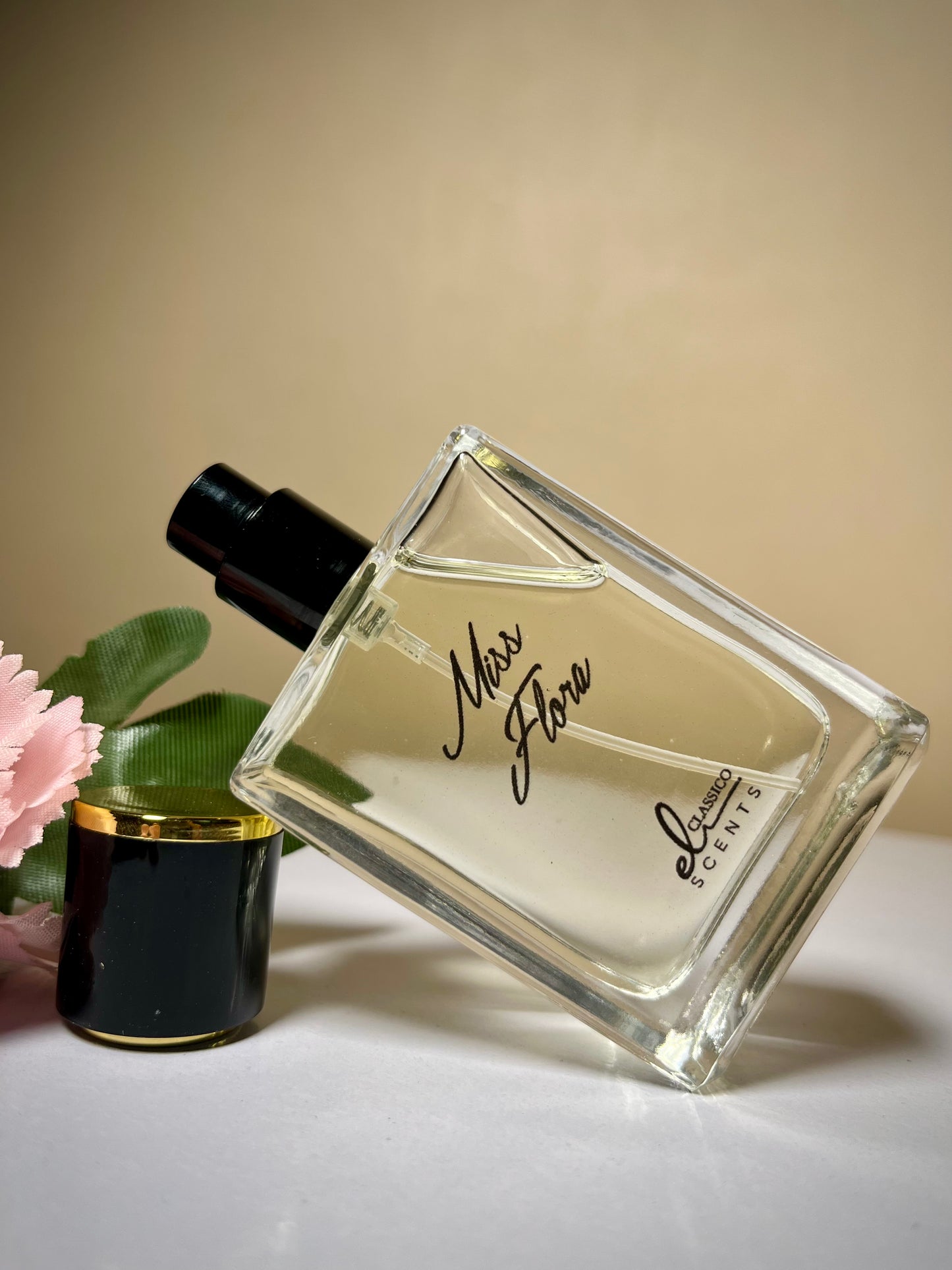 Perfume bottle labeled 'Miss Flora' on a light surface with a blurred background