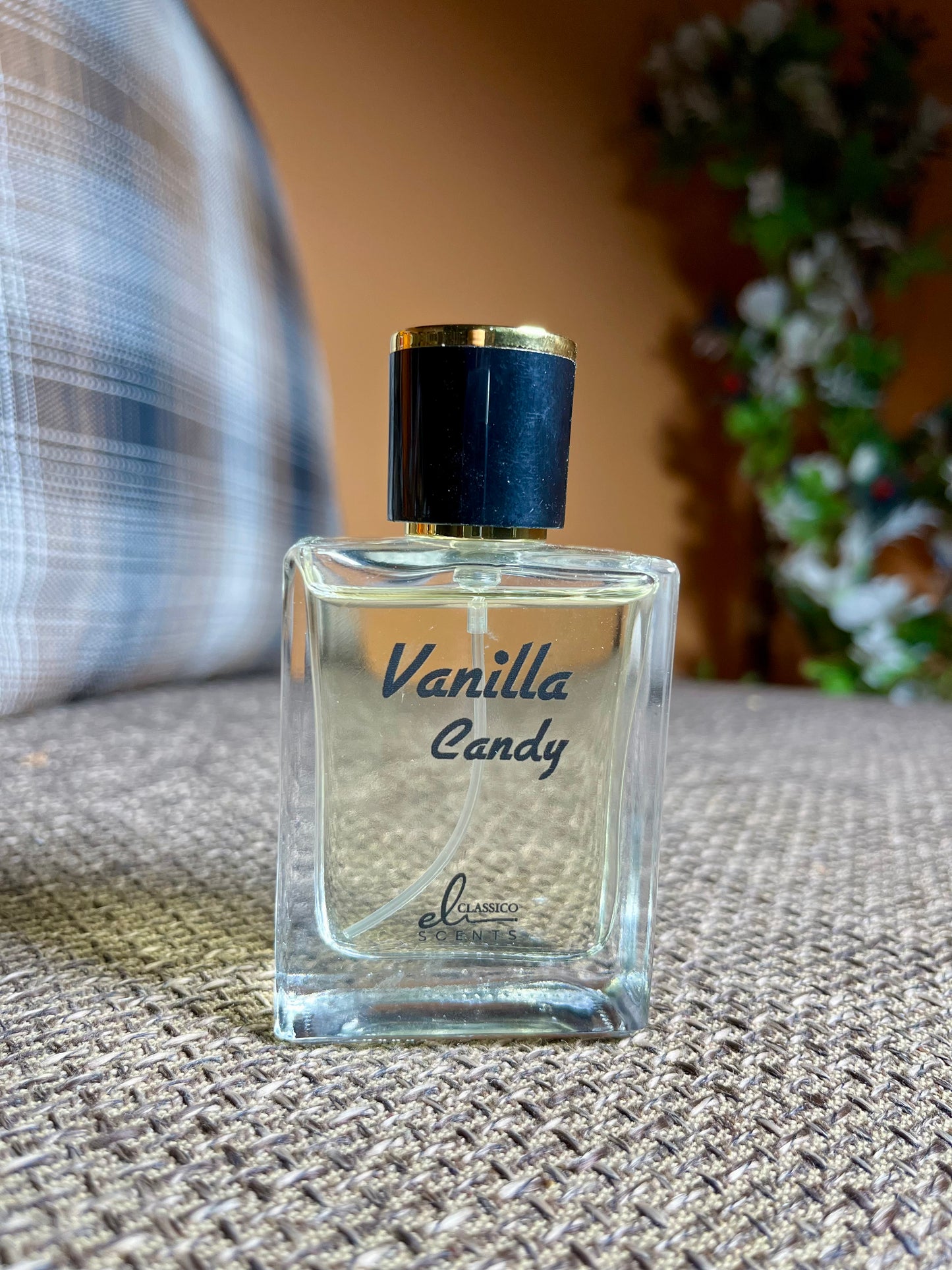 Perfume bottle labeled 'Vanilla Candy' on a textured surface with a blurred background