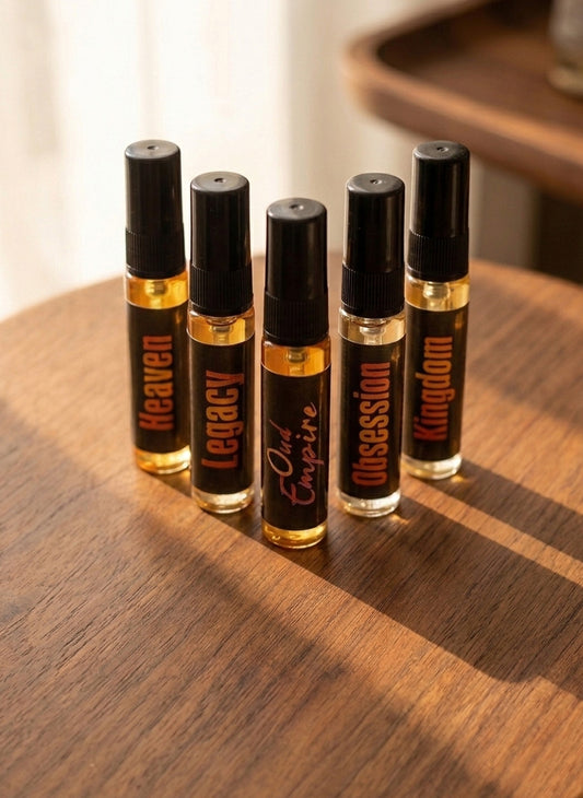 Six small perfume bottles with black caps on a wooden surface